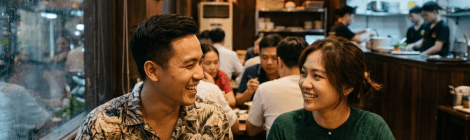 Two people eating pho and spring rolls in a Vietnamese restaurant